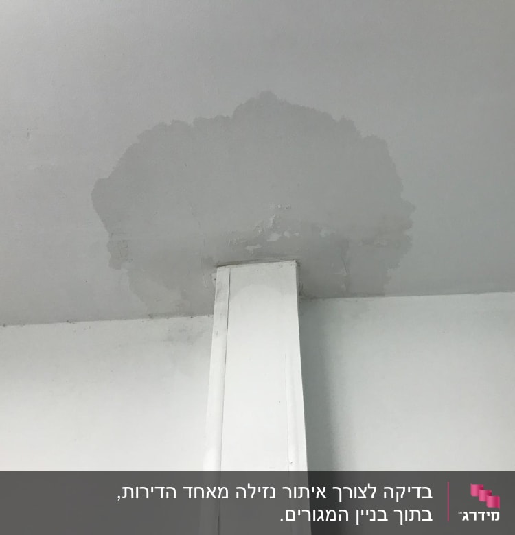 כתם רטיבות בתקרה מעל צינור לבן